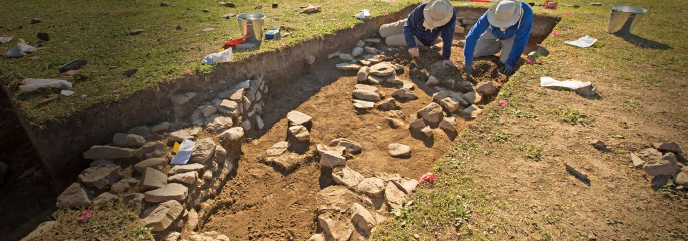 two people work in excavation site